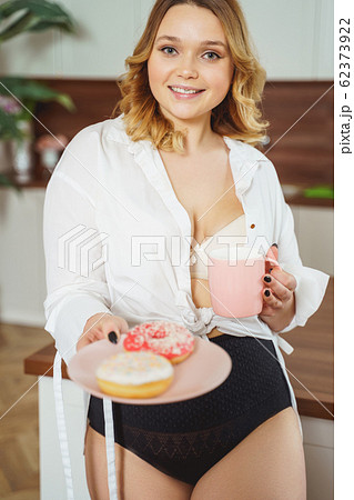 Attractive young female person demonstrating colorful donuts 62373922