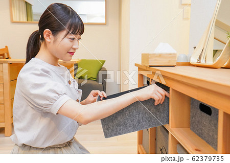 棚の片付けをする若い女性 62379735