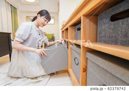 棚の片付けをする若い女性 62379742