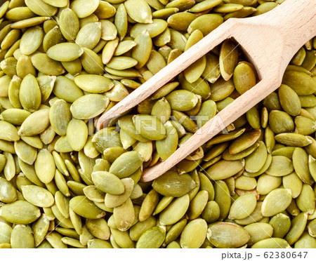 Pumpkin seeds in a wooden spatula, background. The 62380647