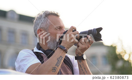 Light-skinned hipster takes a photo of the city 62380873