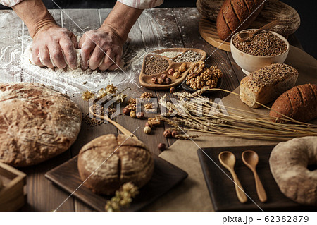 Close up of baker hands kneading dough and making bread with a rolling pin. Close up of baker hands kneading dough and making bread with a rolling pin. 62382879