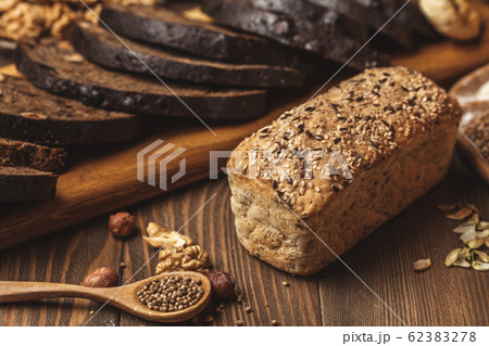 Whole grain multigrain bread, whole and sliced, contains seeds isolated on black 62383278