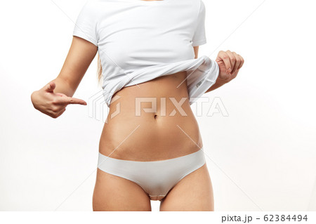 Close up of slim young woman belly isolated on white. Close up of slim young woman belly isolated on white. 62384494