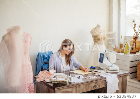 Fashion designer at work. Talanted dressmaker drawing sketch at her workspace 62384837