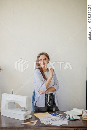 Close-up portrait of young seamstress or dressmaker a her workplace. 62385126