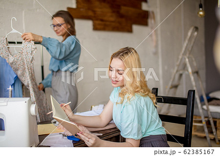 Female seamstress discussing features of the order with client in cozy studio 62385167