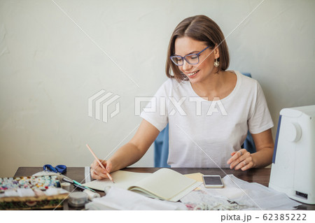 Fashion designer at work. Talanted dressmaker drawing sketch at her workspace Fashion designer at work. Talanted dressmaker drawing sketch at her workspace 62385222