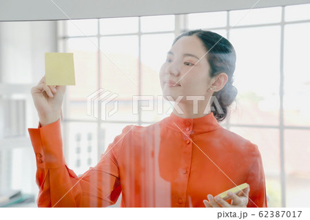 Businesswoman looking at sticky notes 62387017