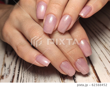 Partial view of manicurist gently holding hand 62388452