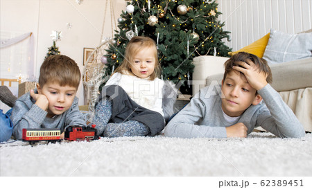 Children playing with railroad at home together in Christmas eve 62389451