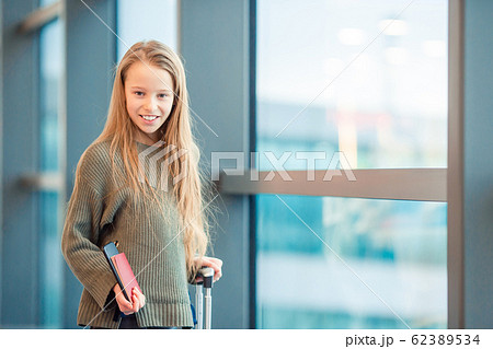 Adorable little girl at airport in big international airport near window 62389534