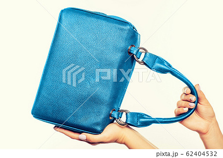female hand holding blue bag isolated 62404532