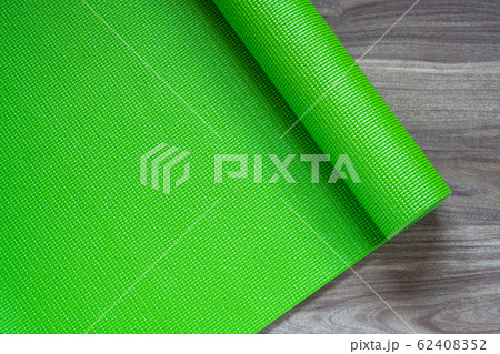Green yoga mat on a wooden background, Top View Green yoga mat on a wooden background, Top View 62408352
