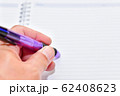 Close-up of hand writing on the note book 62408623