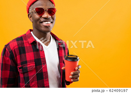 stylish black American man with a beautiful smile in a checkered red shirt holds in his hands a stylish black American man with a beautiful smile in a checkered red shirt holds in his hands a 62409197
