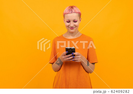 Extraordinary beautiful woman with short pink hair and big tattoo on her hand smiles isolated on 62409282