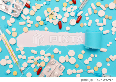 Medications for the treatment of coronavirus, seasonal viral and influenza infections. Thermometer, tablets, syringe in the blue background. Place for text, flat lay, mock up. 62409297