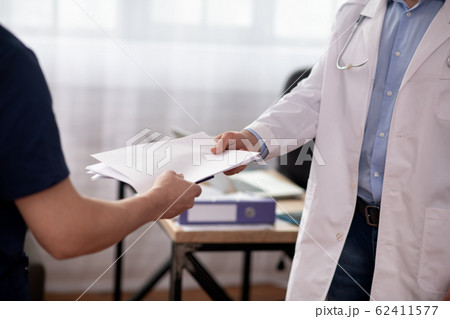Close up picture of mans hands passing the documents Close up picture of mans hands passing the documents 62411577
