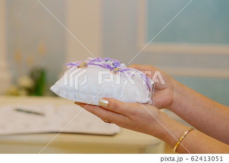 Gold wedding rings on a small pillow. 62413051