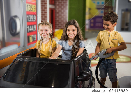 Kids playing gas station in playroom. Kids playing gas station in playroom. 62413989