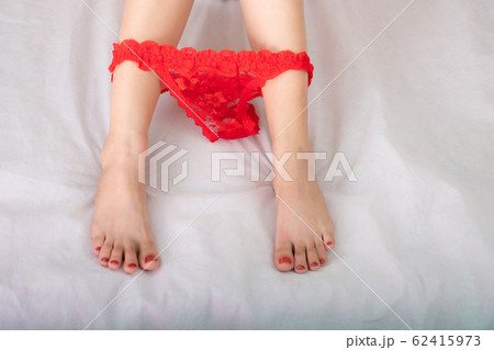 Beautiful leg sexy woman and reclines on the bed with black g-string between feet 62415973
