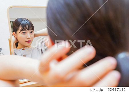 髪のセットをする若い女性 62417112