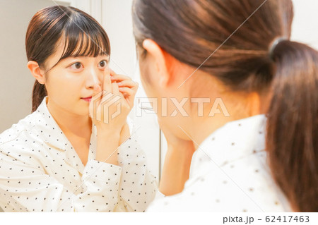コンタクトレンズを装着する若い女性 62417463