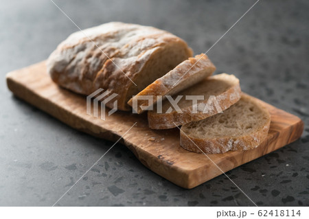 Sliced rustic style ciabatta with rye flour on olive board 62418114
