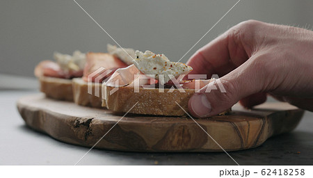 Slow motion man hand take bruschetta with pancetta, ricotta and fig marmalade Slow motion man hand take bruschetta with pancetta, ricotta and fig marmalade 62418258
