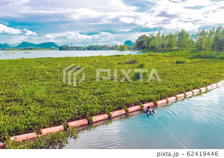 Hunter fisherman with a speargun on a life ring looks under the water in search of fish in the evening. Hunter fisherman with a speargun on a life ring looks under the water in search of fish in the evening. 62419446