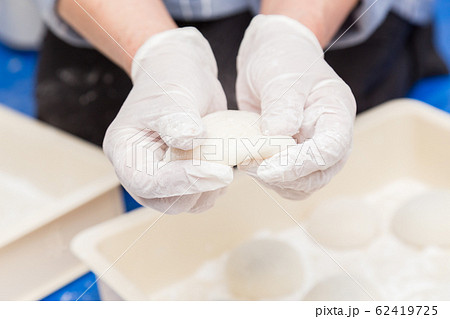 餅つきで餅を丸める女性の手元 62419725