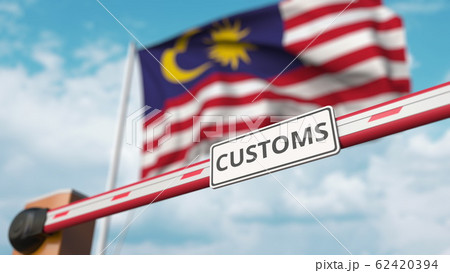 Barrier gate with CUSTOMS sign being closed with flag of Malaysia as a background. Malaysian restricted border crossing or protective tariffs. 3D rendering Barrier gate with CUSTOMS sign being closed with flag of Malaysia as a background. Malaysian restricted border crossing or protective tariffs. 3D rendering 62420394