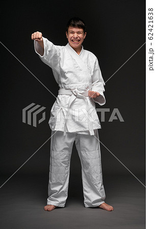 a teenager dressed in martial arts clothing poses 62421638