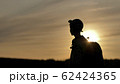 silhouette of a boy with backpack walking at sunset outdoors, travel concept 62424365