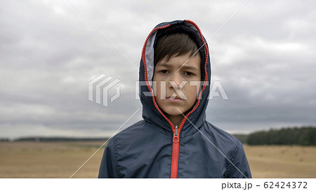 portrait of a serious boy in autumn outdoors, rainy day portrait of a serious boy in autumn outdoors, rainy day 62424372