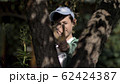 boy hides behind a tree and aims with a slingshot 62424387