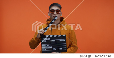 Young man using clapperboard 62424738