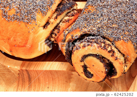 Fresh rolls with poppy seeds on a wooden surface, 62425202