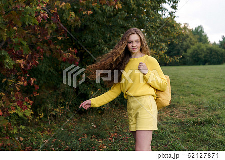 Cheerful smiling teenage girl of 14 years old with long curly red hair 62427874