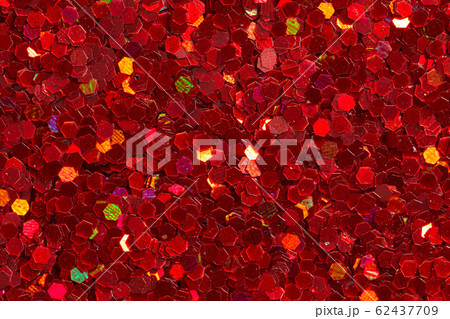 Carmine red figurines on glitter background. Background for creative design or art work. 62437709