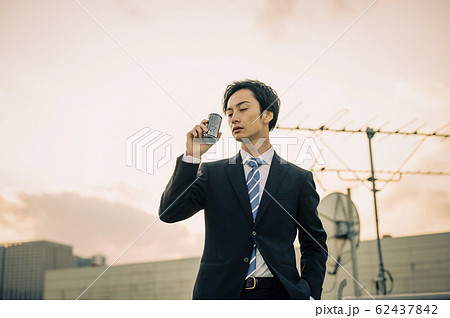 外でコーヒーを飲むビジネスマンの写真素材