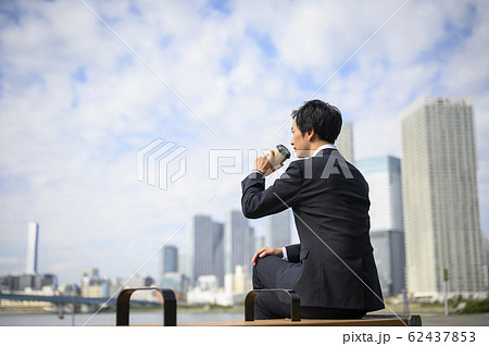 外でコーヒーを飲むビジネスマン 62437853