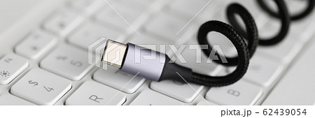 Usb type c cable against laptop keyboard background. 62439054