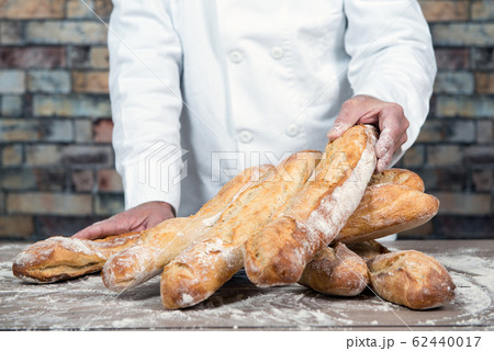 baker with traditional bread french baguettes baker with traditional bread french baguettes 62440017