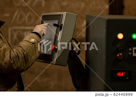 Worker using dashboard of CNC machinery Worker using dashboard of CNC machinery 62440999