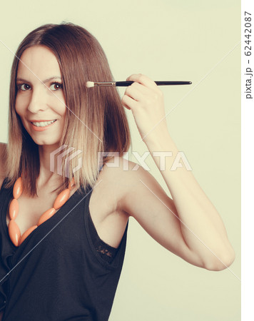 Woman stylist applying eyeshadow with brush. Woman stylist applying eyeshadow with brush. 62442087