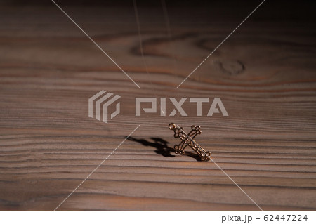 Ornamental golden cross with shadow. 62447224