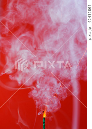 Pyrotechnics wick fuse burning with smoke on red background Pyrotechnics wick fuse burning with smoke on red background 62452865