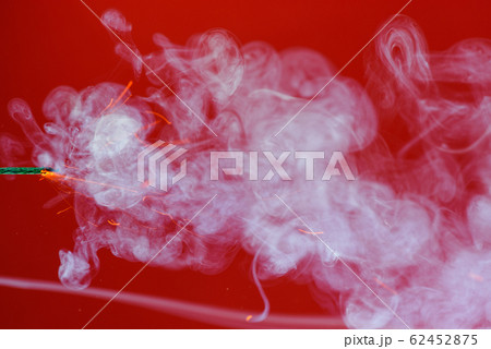 Fuse wick cord burning with sparks and smoke on red background Fuse wick cord burning with sparks and smoke on red background 62452875